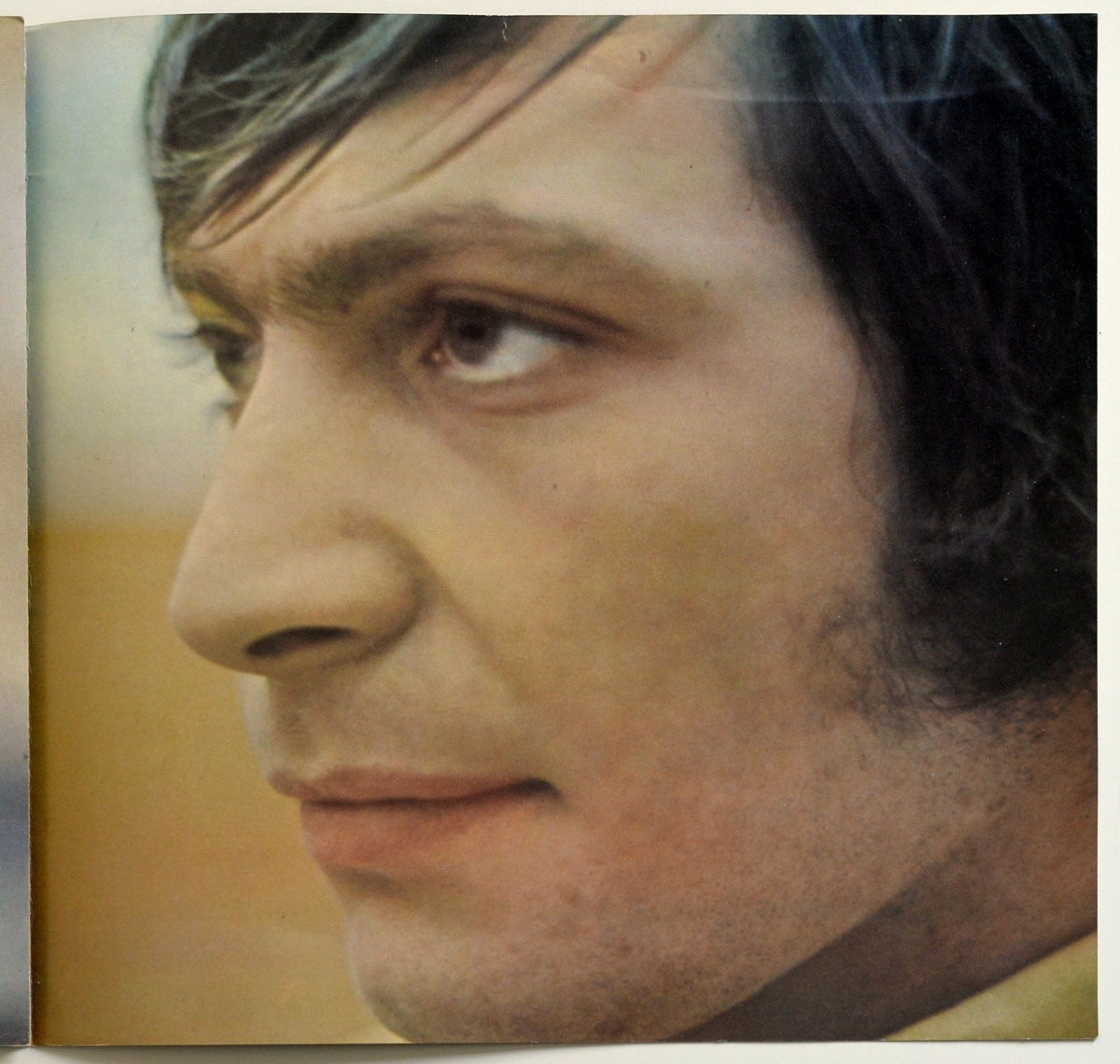 Extreme close-up of Charlie Watts’ face from the 1974 German edition of Rolling Stones’ Big Hits booklet, showing his contemplative gaze and detailed skin texture with soft focus on his eye and hair.